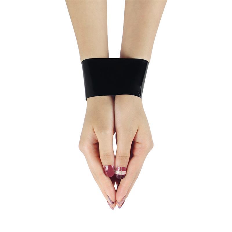 To håndled holdt sammen af et bredt bånd sort bondagetape